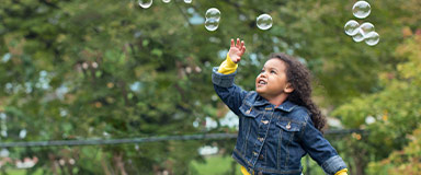 Young girl playing with bubbles
