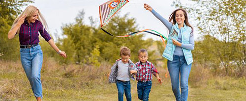 Two women and two young boys, flying a kite